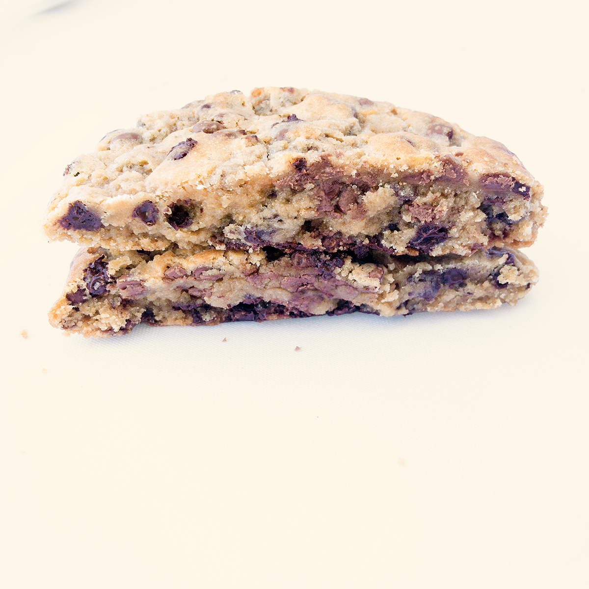 Cookie Milalevain partida por la mitad mostrando su interior esponjoso con pepitas de chocolate derretidas