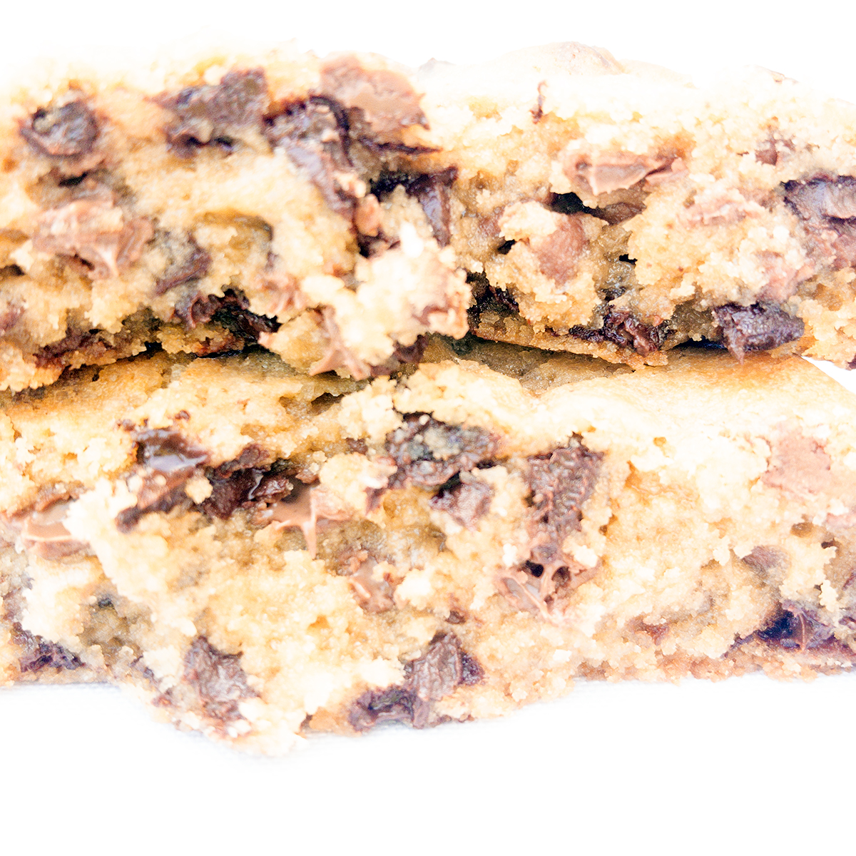 Primer plano del interior de la cookie Milalevain partida, con trozos de chocolate derretido entre una masa tierna y esponjos